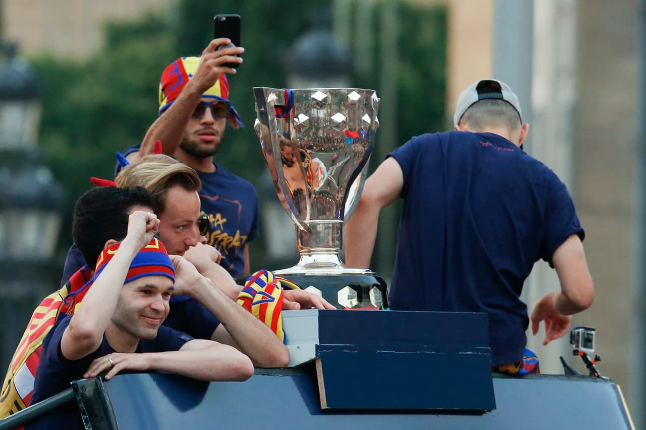 Con dos capitanes al frente del autobús -Andrés Iniesta y Sergio Busquets- la rúa superaba la plaza de España para enfilar la avenida Maria Cristina con las fuentes de Montjuïc de fondo.