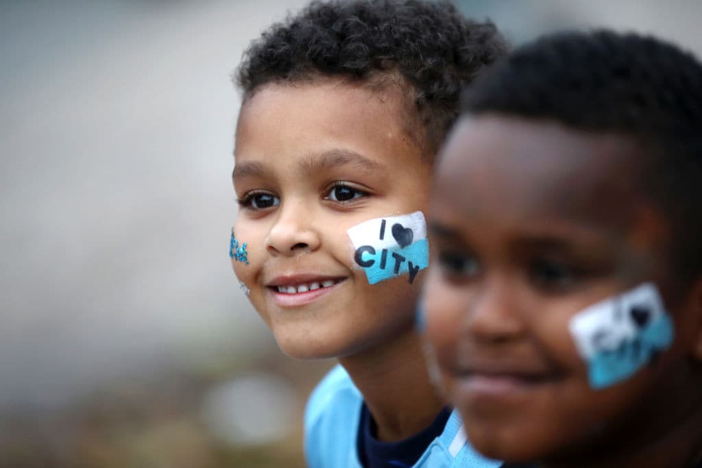 Ilusionados un par de jovenes del Manchester City miran hacia el horizonte con los colores bien adheridos a sus rostros, no cabe duda que son aficionados de cepa.