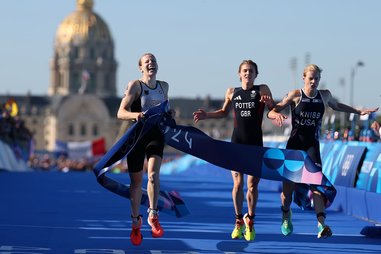 PARIS, FRANCE - AUGUST 05: Laura Lindemann of Team Germany crosses the finish line to win the Gold medal ahead of Beth Potter of Team Great Britain and Taylor Knibb of Team United States during the Mixed Relay on day ten of the Olympic Games Paris 2024 at Pont Alexandre III on August 05, 2024 in Paris, France. (Photo by Al Bello/Getty Images)