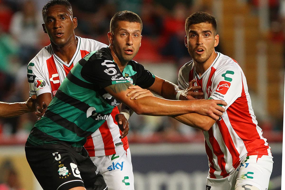 Disputa por el balón en el juego aéreo, donde observa el hondureño de Necaxa Bryan Beckeles (izquierda).