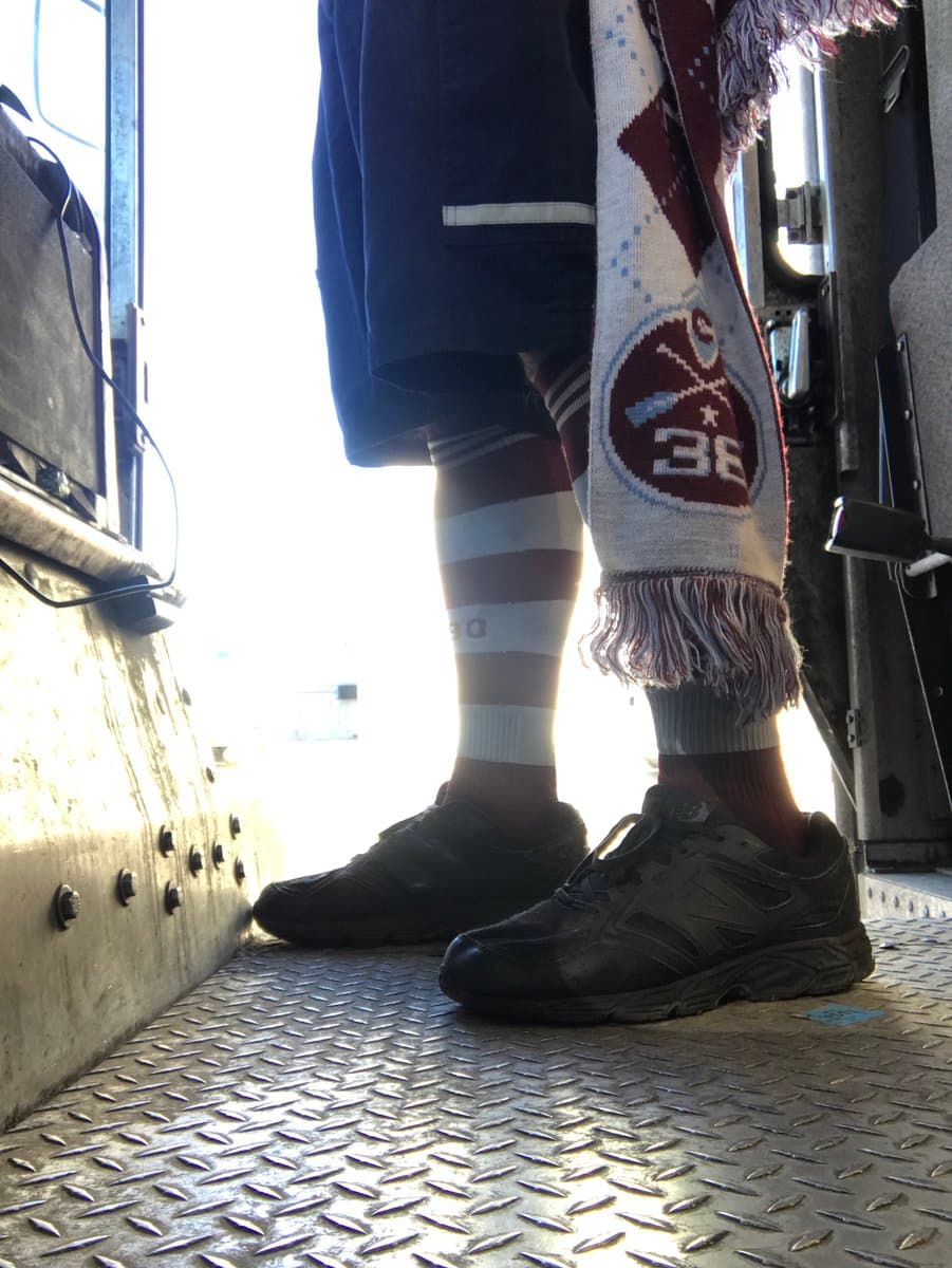 Este aficionado de Colorado Rapids lleva uniforme obligatorio al trabajo, pero nadie le puede impedir vestir calcetines del club de sus amores.