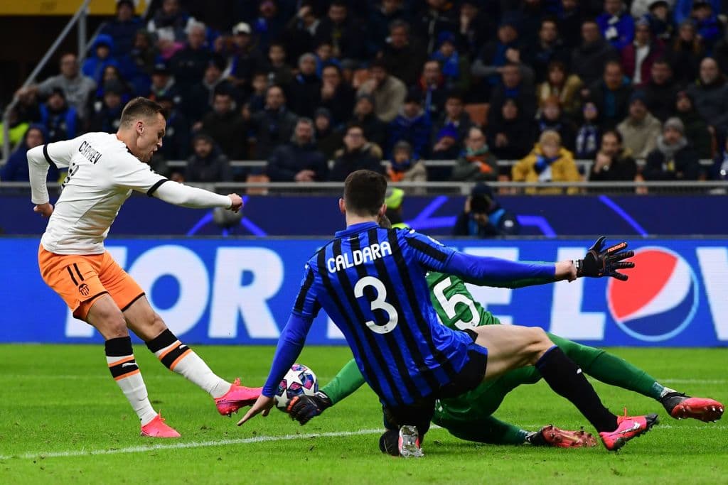 Valencia's Russian midfielder Denis Cheryshev (L) shoots on goal during the UEFA Champions League round of 16 first leg football match Atalanta Bergamo vs Valencia on February 19, 2020 at the San Siro stadium in Milan. (Photo by Miguel MEDINA / AFP) (Photo by MIGUEL MEDINA/AFP via Getty Images)
