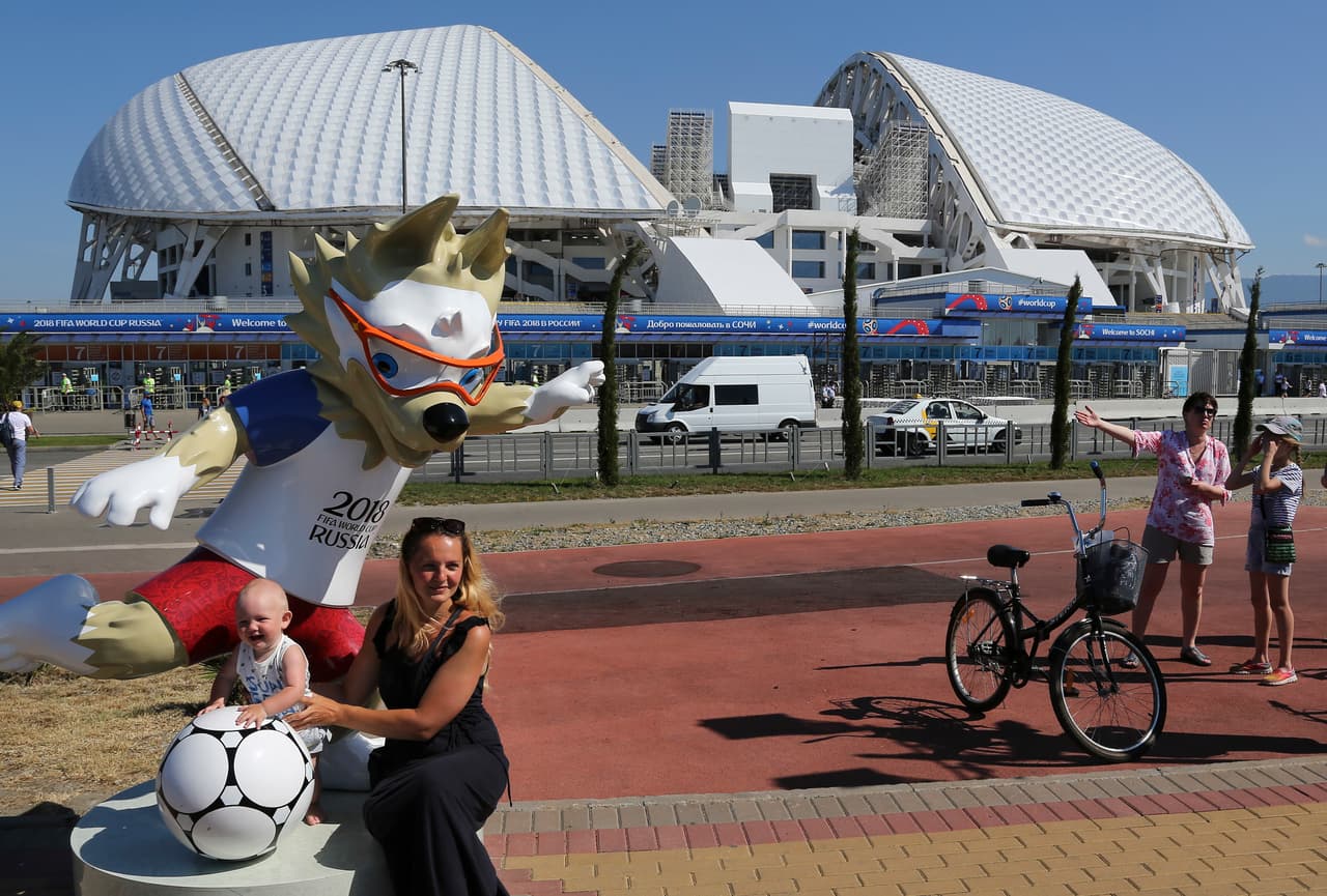 A woman with her daughter poses for a picture next to the official mascot Zabivaka in front of the Fisht stadium, which will host some 2018 World Cup matches in Sochi, Russia, Wednesday, June 13, 2018. (AP Photo/Andre Penner)