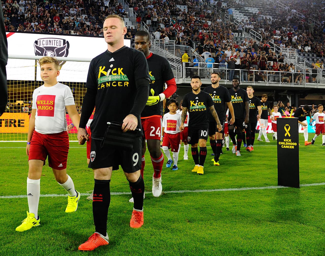 Sep 2, 2018; Washington, DC, USA; D.C. United forward Wayne Rooney (9) is escorted on to the field before the game against the Atlanta United at Audi Field. Mandatory Credit: Brad Mills-USA TODAY Sports