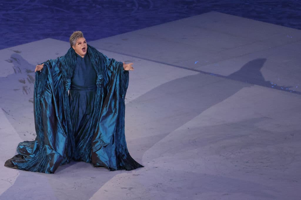 La soprano japonesa Tomotaka Okamoto entonó el Himno del Comité Olímpico Internacional, mientras unos jets en pleno vuelo difuminaban humo blanco, rojo y azul, semejando la bandera de Francia, la próxima sede.