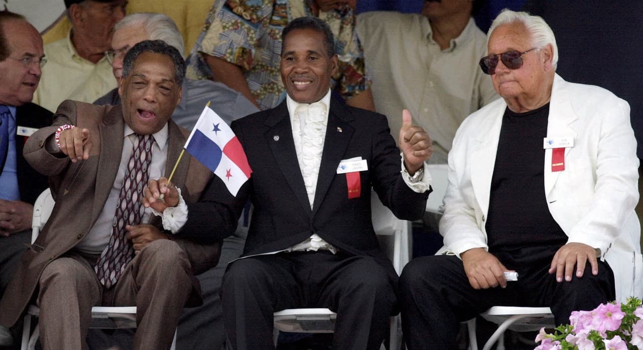 International Boxing Hall of Fame inductees Sugar Ramos of Mexico, left, and Ismael Laguna of Panama, center, recognize familiar faces in the audience as fellow inductee, promoter Don Chargin, looks on during the induction ceremony in Canastota, N.Y., Sunday, June 10, 2001. (AP Photo/Kevin Rivoli)