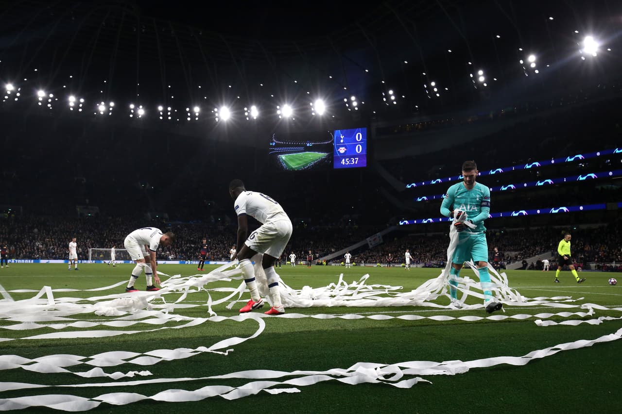 Jugadores del Tottenham sacan todo el papel que aventaron los aficionados de los Spurs en el partido.