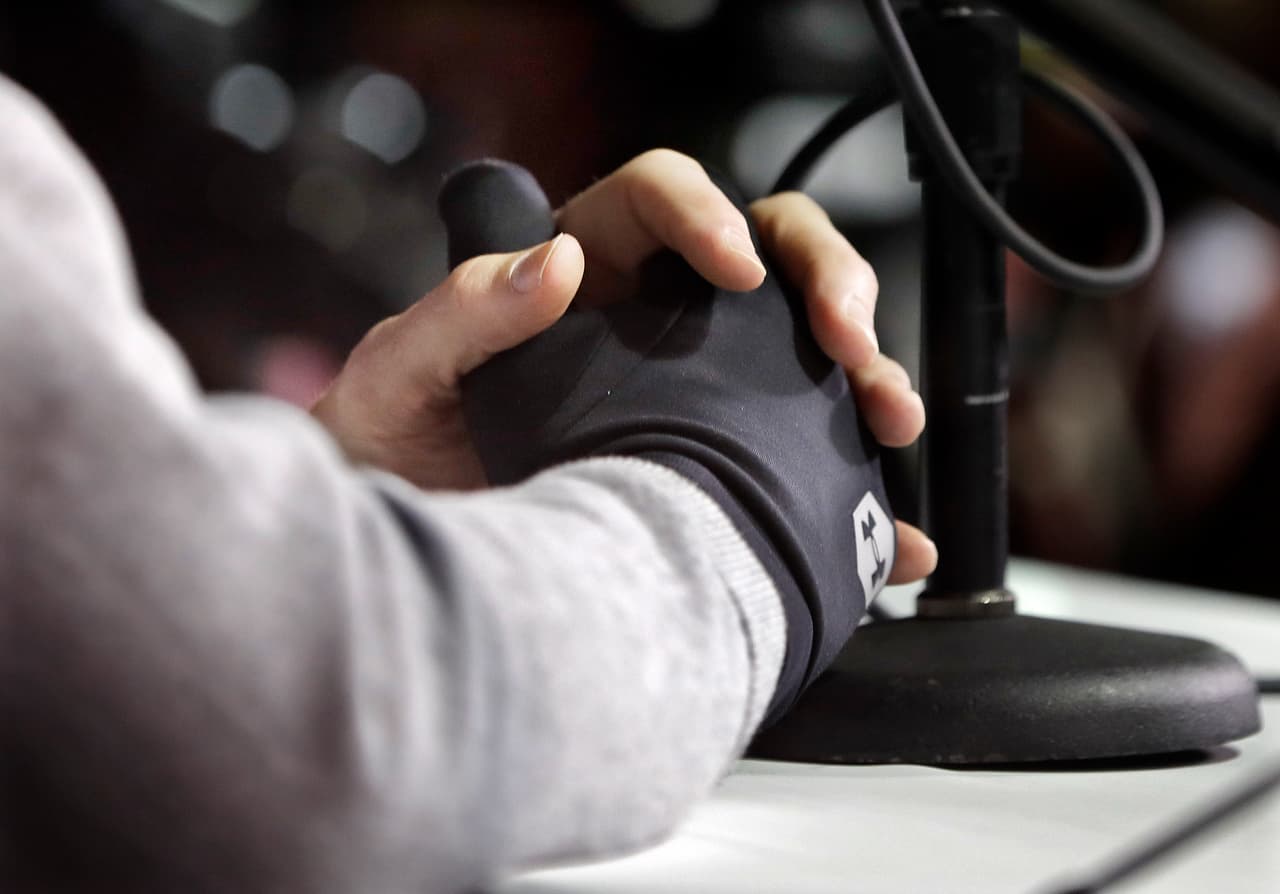 New England Patriots quarterback Tom Brady wears a glove on his injured right hand as he answers questions during a news conference Tuesday, Jan. 30, 2018, in Minneapolis. The Patriots are scheduled to face the Philadelphia Eagles in the NFL Super Bowl 52 football game Sunday, Feb. 4. (AP Photo/Mark Humphrey)