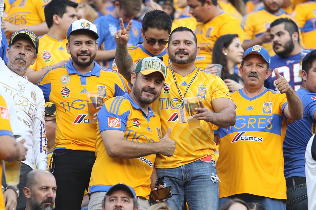 Los buenos amigos de Tigres comparten con alegría en el Estadio Universitario.