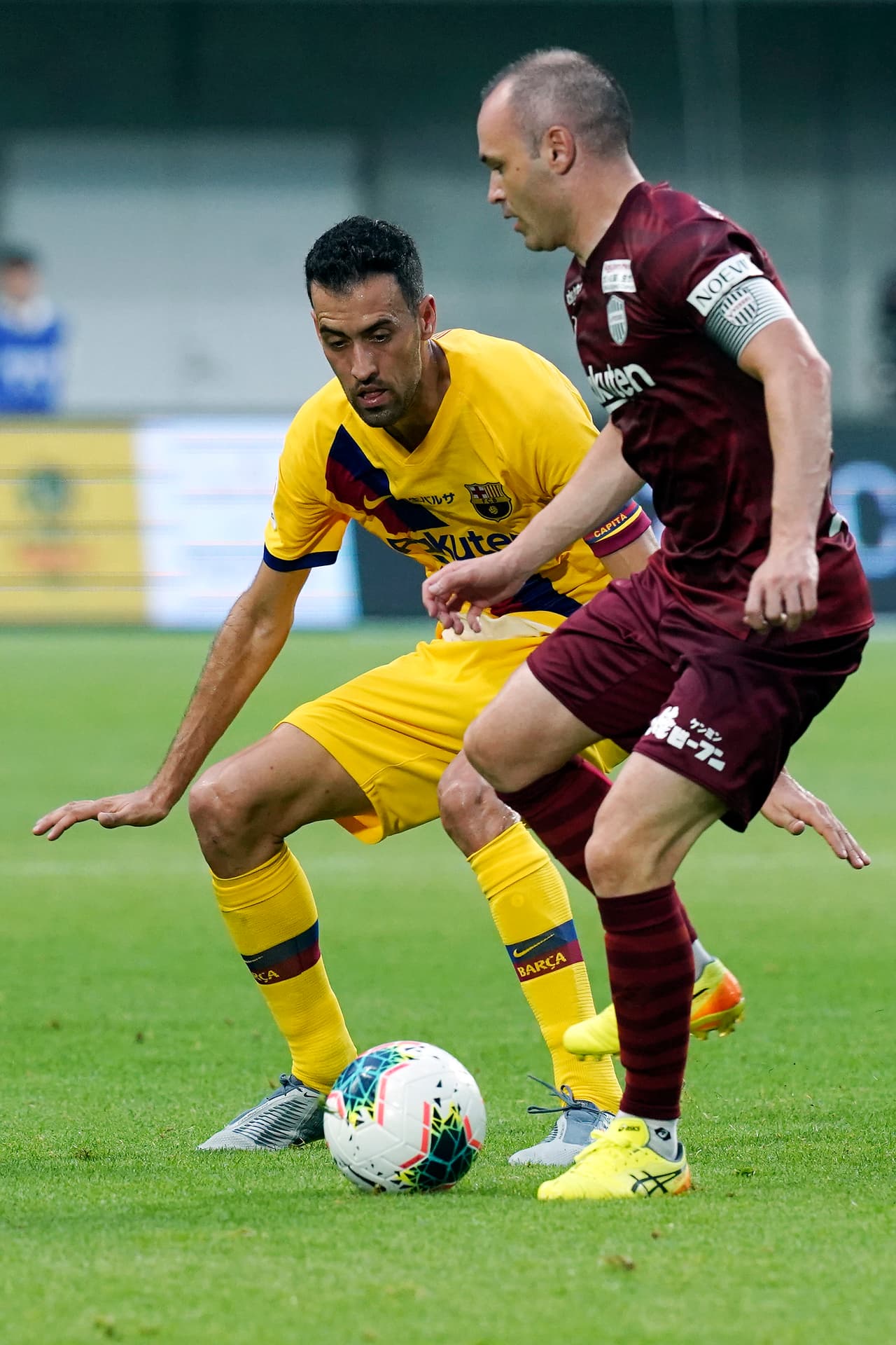 Andrés Iniesta protege el esférico ante la presión de su excompañero Sergio Busquets.