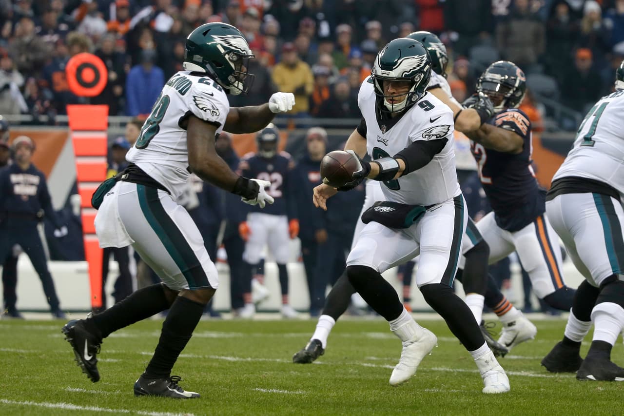 Philadelphia Eagles quarterback Nick Foles (9) hands off the ball to running back Wendell Smallwood (28) during the first half of an NFL wild-card playoff football game against the Chicago Bears Sunday, Jan. 6, 2019, in Chicago. (AP Photo/David Banks)