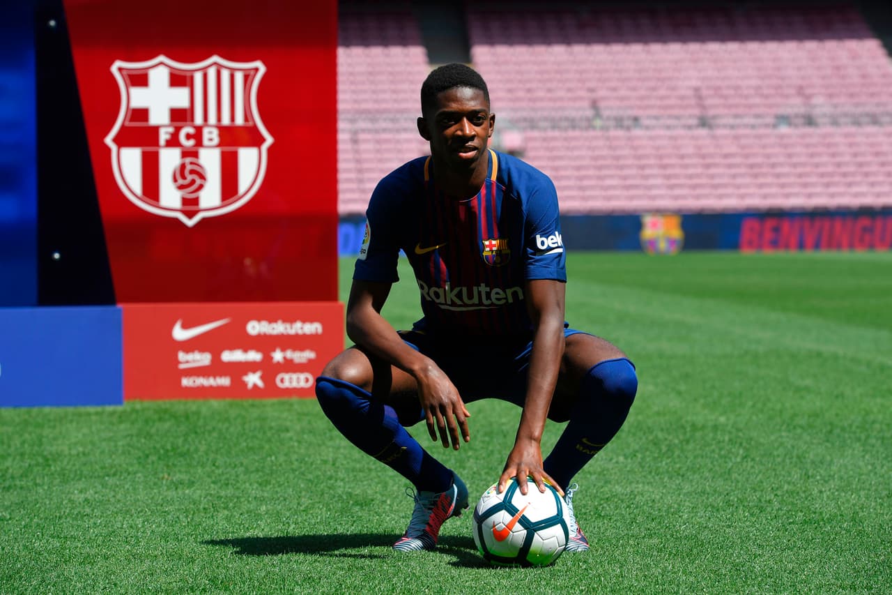 Barcelona's new player Ousmane Dembele poses with a ball at the Camp Nou stadium in Barcelona, during his official presentation by the Catalan football club, on August 28, 2017. French starlet Ousmane Dembele agreed a five-year deal with Barcelona worth 105 million euros ($125 million) plus add-ons. Dembele, 20, moves from Borussia Dortmund, where he has been suspended since he boycotted training on August 10 in protest after the German club rejected Barca's first bid. / AFP PHOTO / LLUIS GENE (Photo credit should read LLUIS GENE/AFP/Getty Images)