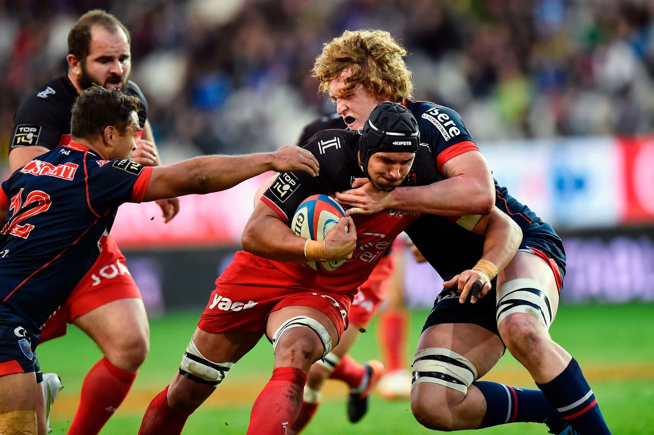 Toulon's South African lock Juandre Kruger (C) is challenged by Grenoble's French lock Thomas Jolmes (R) and Grenoble's New Zealander centre Nigel Hunt (L) during the French Top 14 rugby union match between FC Grenoble (FCG) and RC Toulon (RCT) on March 19, 2017 at the Stade des Alpes Stadium in Grenoble, central-eastern France. / AFP PHOTO / ROMAIN LAFABREGUE (Photo credit should read ROMAIN LAFABREGUE/AFP/Getty Images)