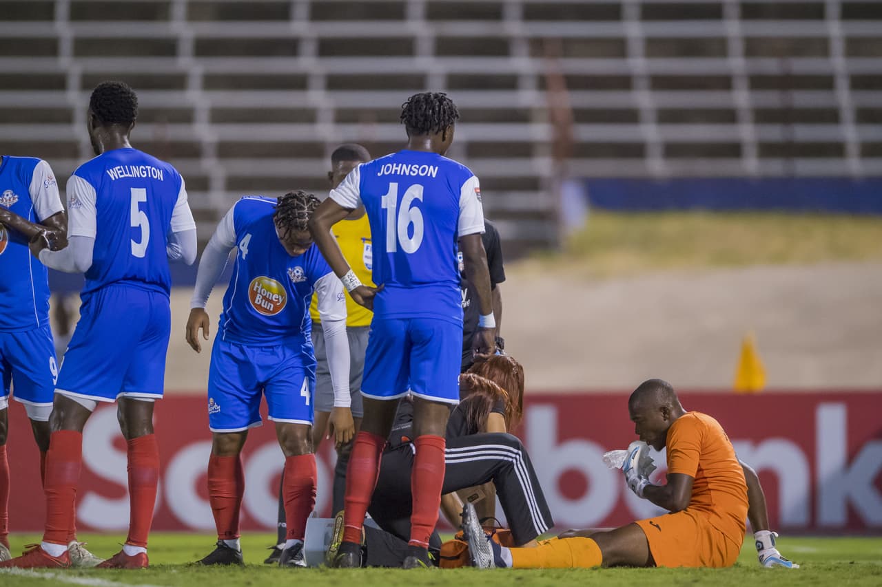 Kemar Foster es atendido luego de un fuerte choque con el delantero Lucas Passerini.