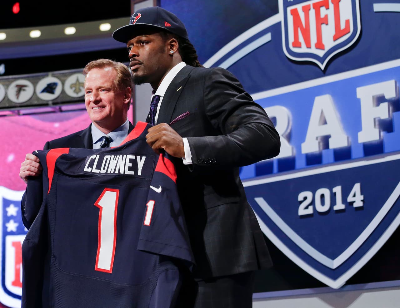 2014 JADEVEON CLOWNEY | DE South Carolina - 
<b>Houston Texans</b>
<br>
<br>El ala defensiva de Carolina del Sur, Jadeveon Clowney, sostiene el jersey de la primera selección global luego de que los Houston Texans lo tomaron en la primera ronda del Draft de la NFL de 2014. Aquí se le ve junto al comisionado de la NFL, Roger Goddell, el jueves 8 de mayo de 2014 en Nueva York.