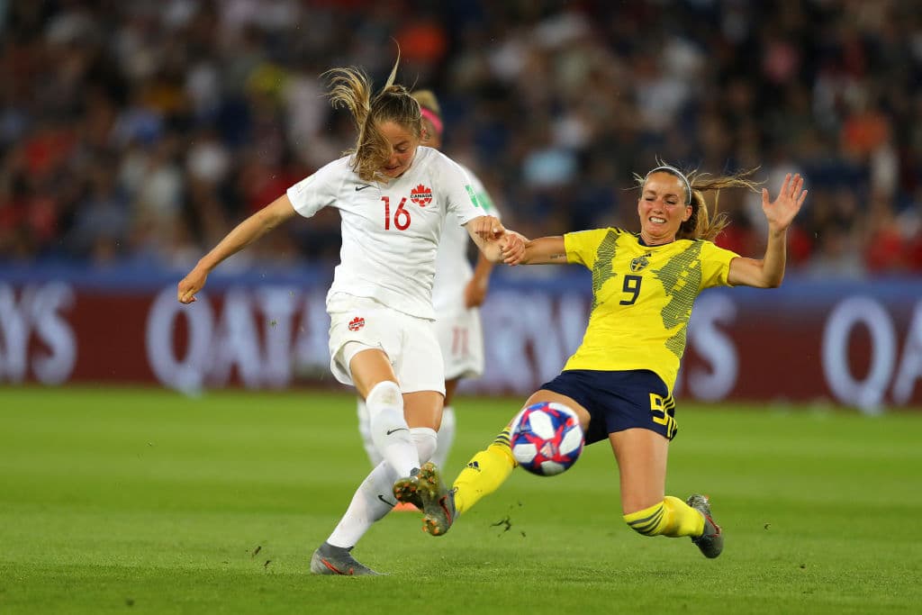 En una de las primeras aproximaciones de cara a gol, por parte de Janine Beckie de Canadá, mientras Kosovare Asllani (9) de Suecia se esfuerza por bloquear el disparo.