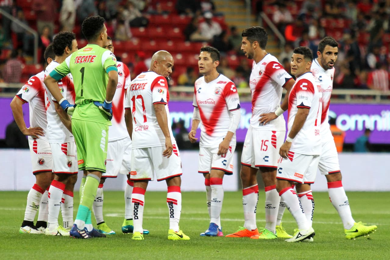 Al terminar el primer tiempo, los tiburones se reunen al centro del campo.