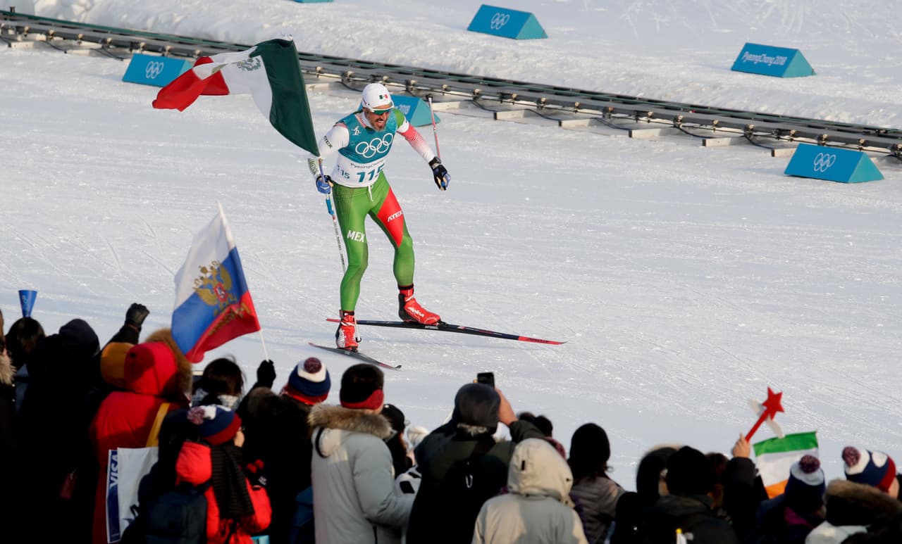 El mexicano Germán Madrazo, toma la bandera de su país luego terminar último en los 15 kilómetros libres de esquí de fondo en los Juegos Olímpicos de Invierno, el viernes 16 de febrero de 2018, en Pyeongchang, Corea del Sur (AP Foto/Dmitri Lovetsky)