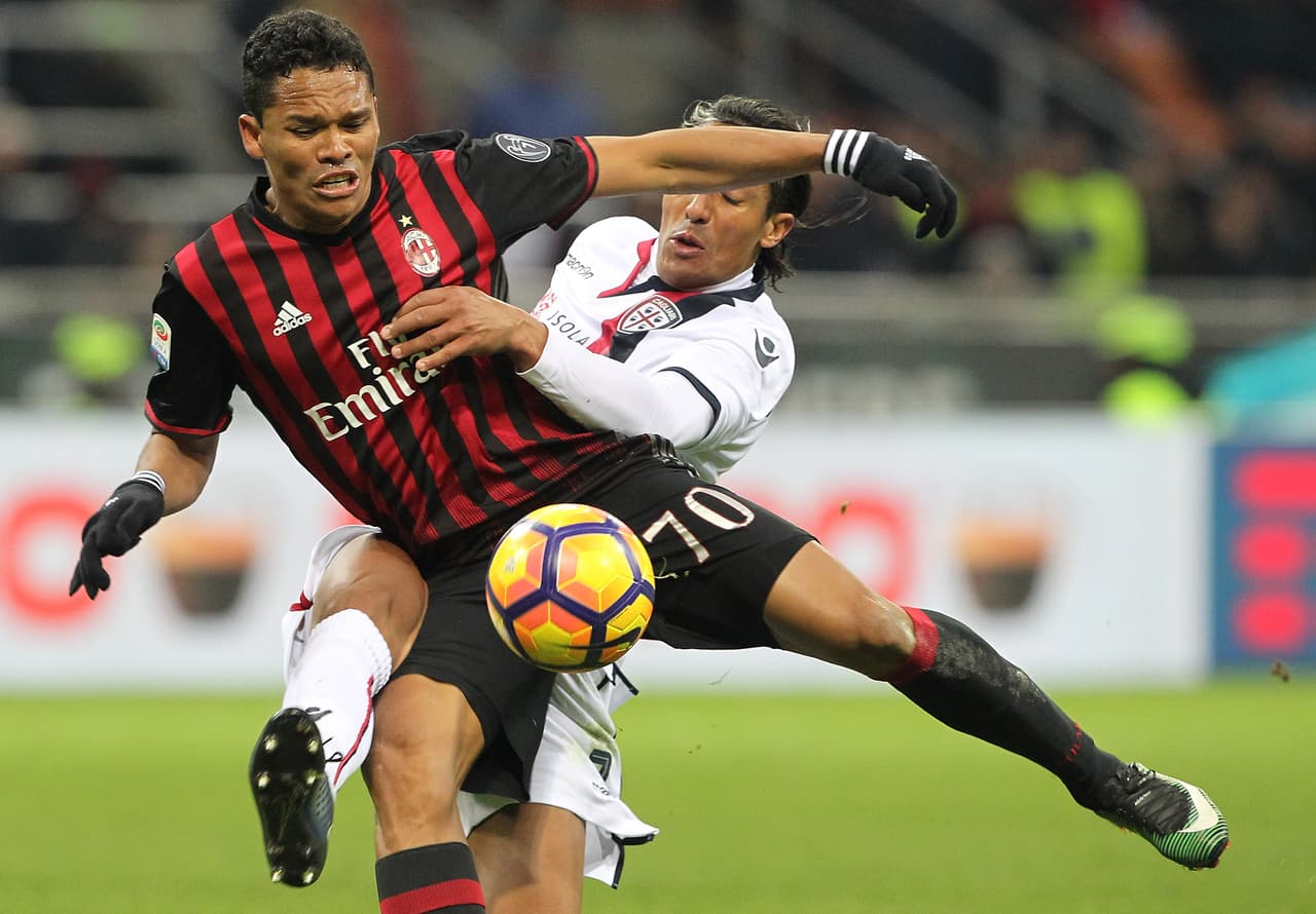 MILAN, ITALY - JANUARY 08: Carlos Bacca of AC Milan competes for the ball with Bruno Eduardo Alves of Cagliari Calcio during the Serie A match between AC Milan and Cagliari Calcio at Stadio Giuseppe Meazza on January 8, 2017 in Milan, Italy. (Photo by Marco Luzzani/Getty Images)
