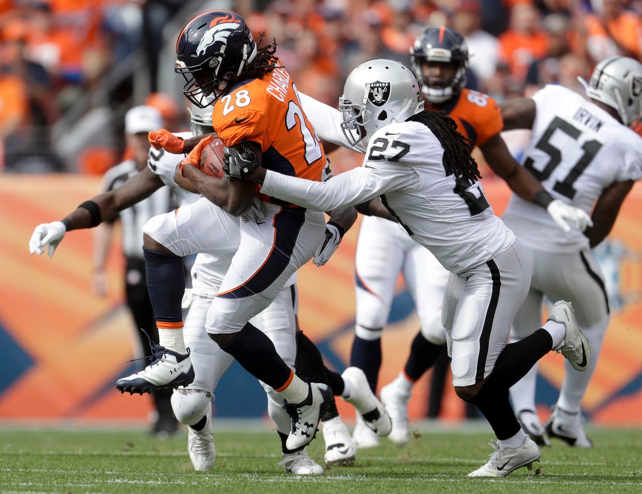 Los Broncos de Denver recibieron a unos alicaídos Raiders y fueron dominantes en defensa. Aquí Jamaal Charles evita una tackleada en la primera mitad.