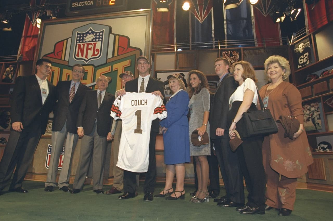 1999 TIM COUCH | QB Kentucky - 
<b>Cleveland Browns</b>
<br>
<br>El ex mariscal de campo de Kentucky, Tim Couch, posa junto a su familia y con el dueño de los Cleveland Browns, Al Lerner, después de que los Browns lo convirtieron en la selección número uno en el draft de la NFL en Nueva York el 17 de abril de 1999.