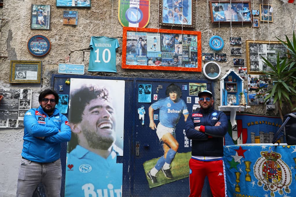 Dos fans del Napoli posan fuera de un local que muestra la historia de Diego Armando Maradona, el jugador más grande que ha tenido el equipo del sur de Italia.