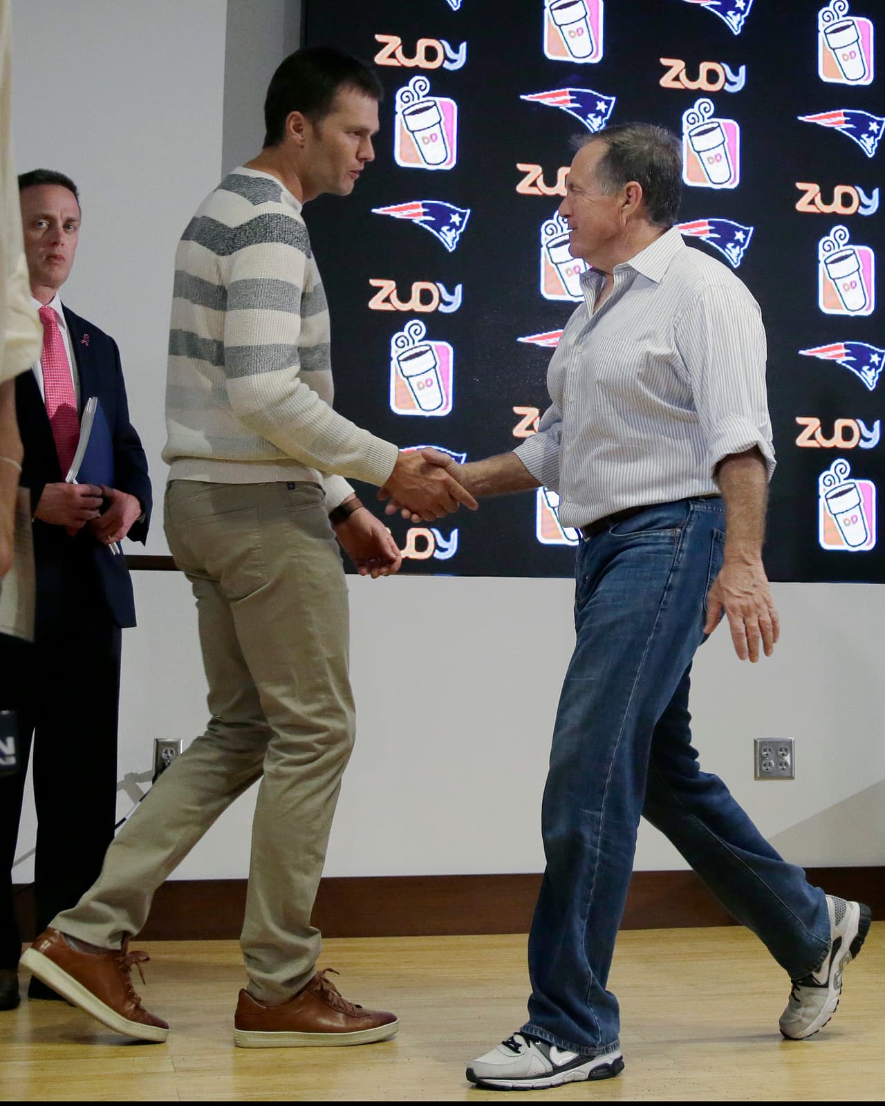 New England Patriots quarterback Tom Brady, left, shakes hands with head coach Bill Belichick as he arrives to speak to the media following an NFL football game against the Cincinnati Bengals, Sunday, Oct. 16, 2016, in Foxborough, Mass. (AP Photo/Elise Amendola)