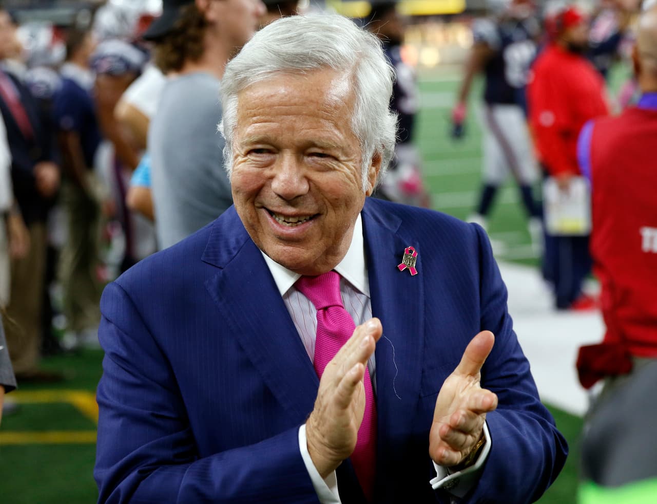 New England Patriots Chairman and CEO, Robert Kraft talks with others on the field as the team warms up before an NFL football game against the Dallas Cowboys, Sunday, Oct. 11, 2015, in Arlington, Texas. (AP Photo/Roger Steinman)