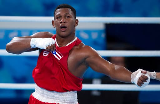En la imagen aparece Alvin Canales de Puerto Rico, quien muestra su bandera luego de conquistar la medalla de bronce en el combate por el tercer lugar de la categoría de los pesados.