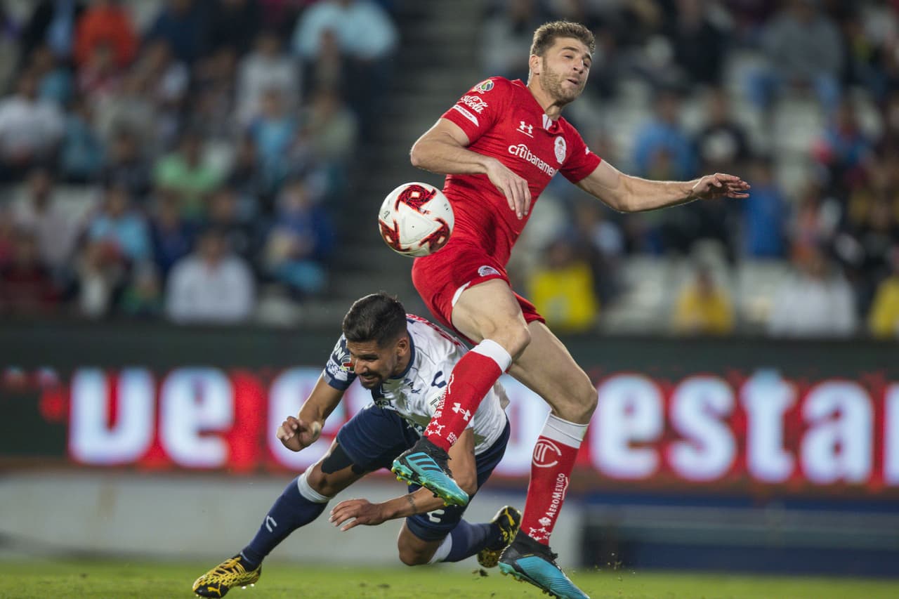Franco Jara pelea la bola y comete falta sobre el jugador de Toluca Gaston Sauro.