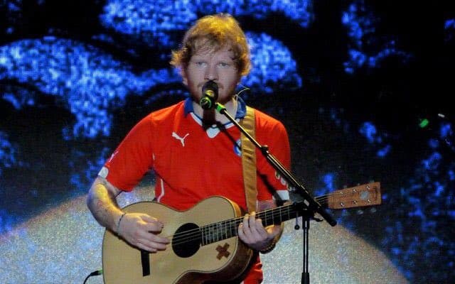 Ed Sheeran se puso la camiseta de Chile en un concierto, pero no ha sido el único música que lo ha hecho. Te dejamos algunas fotos de músicos con camisetas de futbol. ¿Te imaginas a Julian Casablancas con la camiseta de Pumas?