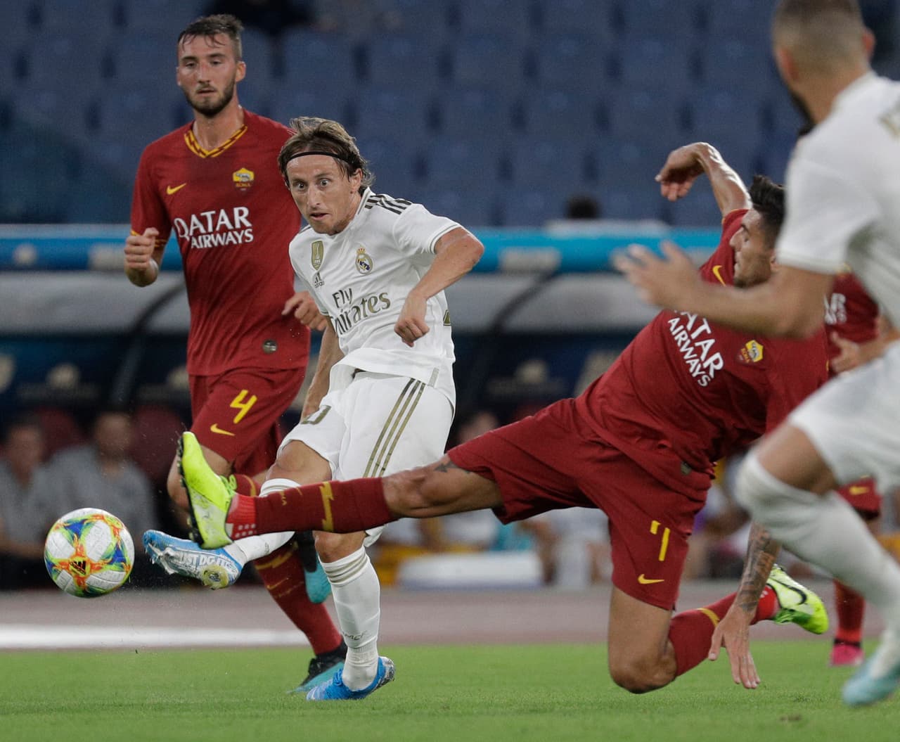 Luka Modric dispara ante la barrida de Lorenzo Pellegrini.