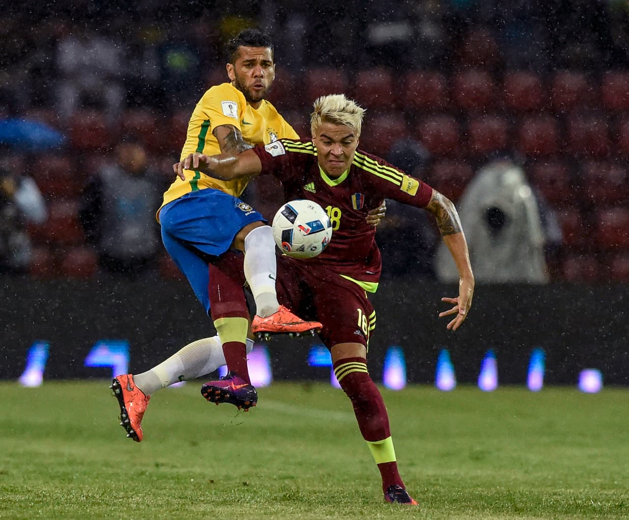 Brazil's Dani Alves and Venezuela's midfielder Adalberto Penaranda vie for the ball during their Russia 2018 World Cup football qualifier match in Merida, Venezuela, on October 11, 2016. / AFP / JUAN BARRETO (Photo credit should read JUAN BARRETO/AFP/Getty Images)