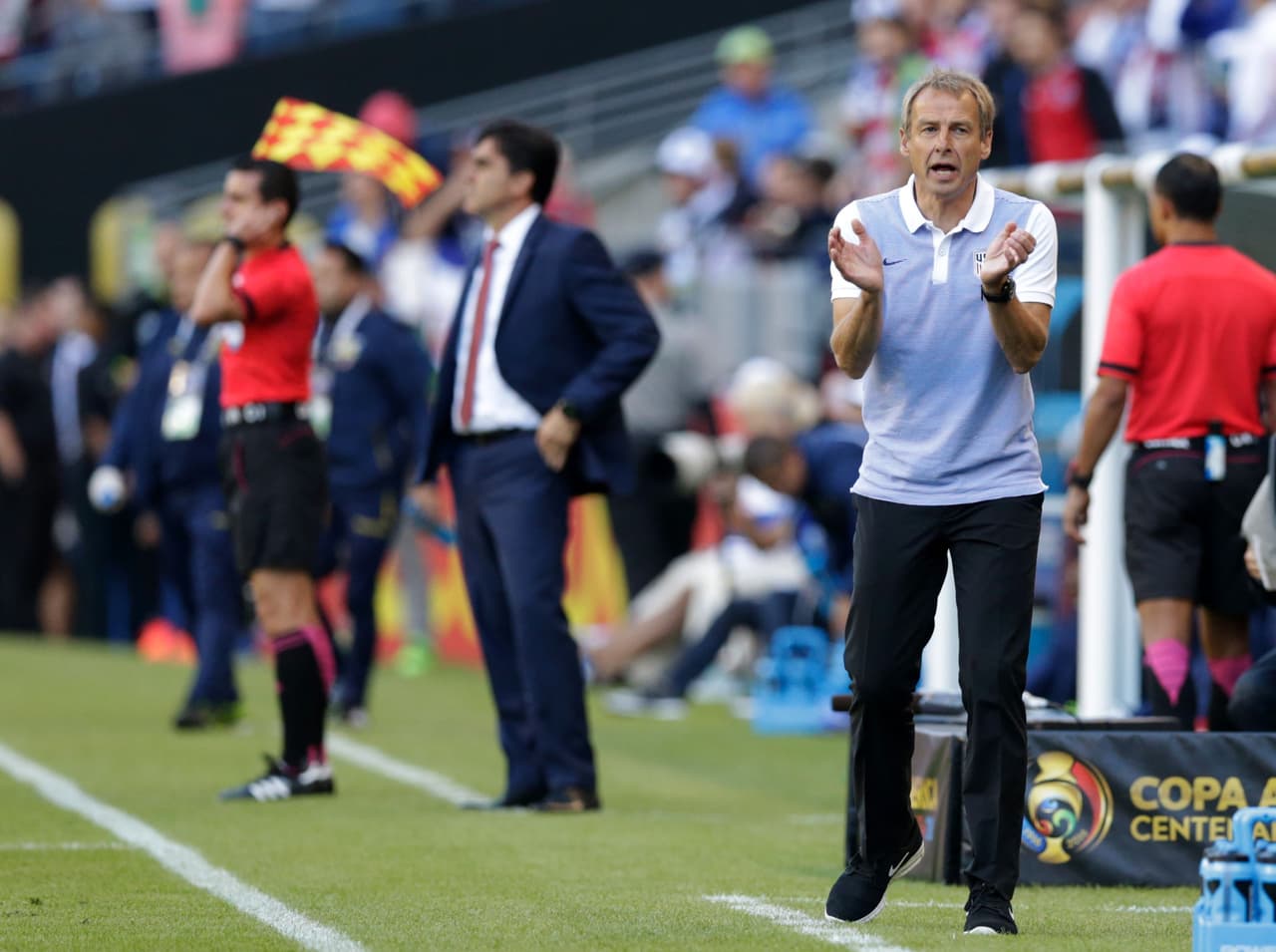 Jurgen Klinsmann, técnico de la selección de Estados Unidos, da ordenes y anima al equipo en medio del encuentro. Al fondo, Gustavo Quinteros, el técnico de Ecuador.
