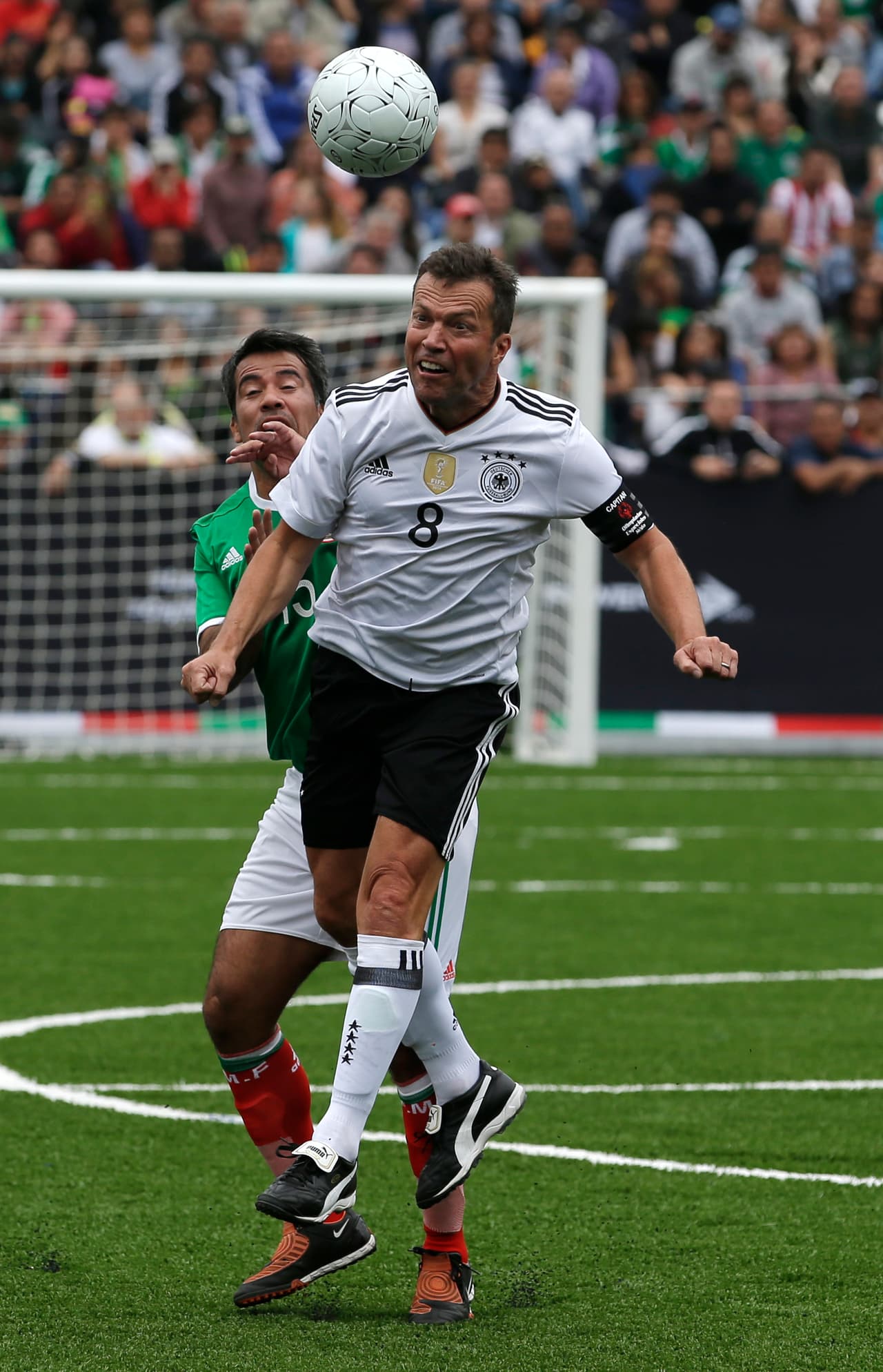 Germany's Lothar Matthaus, front, leaps over Mexico's Pavel Pardo to control the ball during a pair of "revenge" matches between former pro players from the Mexican and German national soccer teams in the Zocalo, Mexico City's main square, Sunday, July 9, 2017. The matches pitted against each other former players primarily from the 1986 and 1998 World Cup teams. (AP Photo/Rebecca Blackwell)