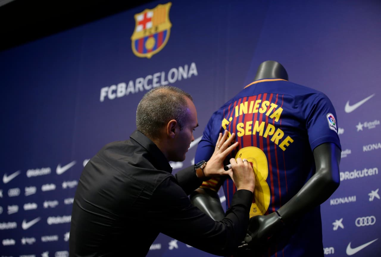 El jugador del Barcelona, Andrés Iniesta, firma una camiseta tras firmar un contrato vitalicio con el club el viernes, 6 de octubre de 2017, en Barcelona. (AP Foto/Manu Fernandez)
