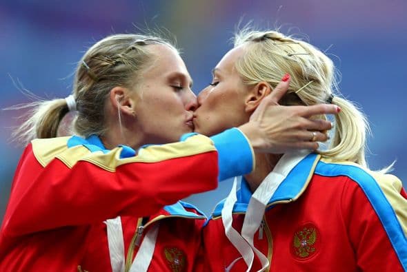Gushchina y Ryzhova de Rusia se besaron en el podio al recibir su medalla de oro en el relevo 4x400 en los Mundiales de Moscú 2013.