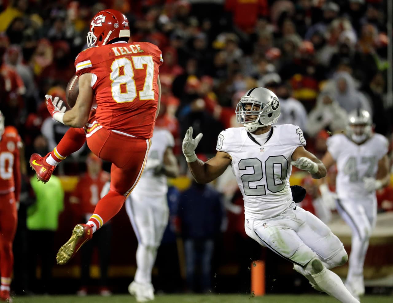 Kansas City Chiefs tight end Travis Kelce (87) makes a catch in front of Oakland Raiders safety Nate Allen (20) during the second half of an NFL football game in Kansas City, Mo., Thursday, Dec. 8, 2016. (AP Photo/Charlie Riedel)