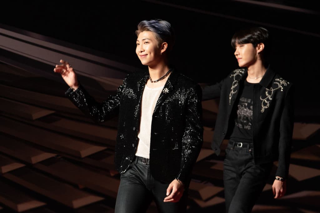 Lider de la banda BTS que catapultó la búsqueda de playeras de cuello de tortuga y chamarras blancas, tras ser visto en las calles de Nueva York con este estilo.