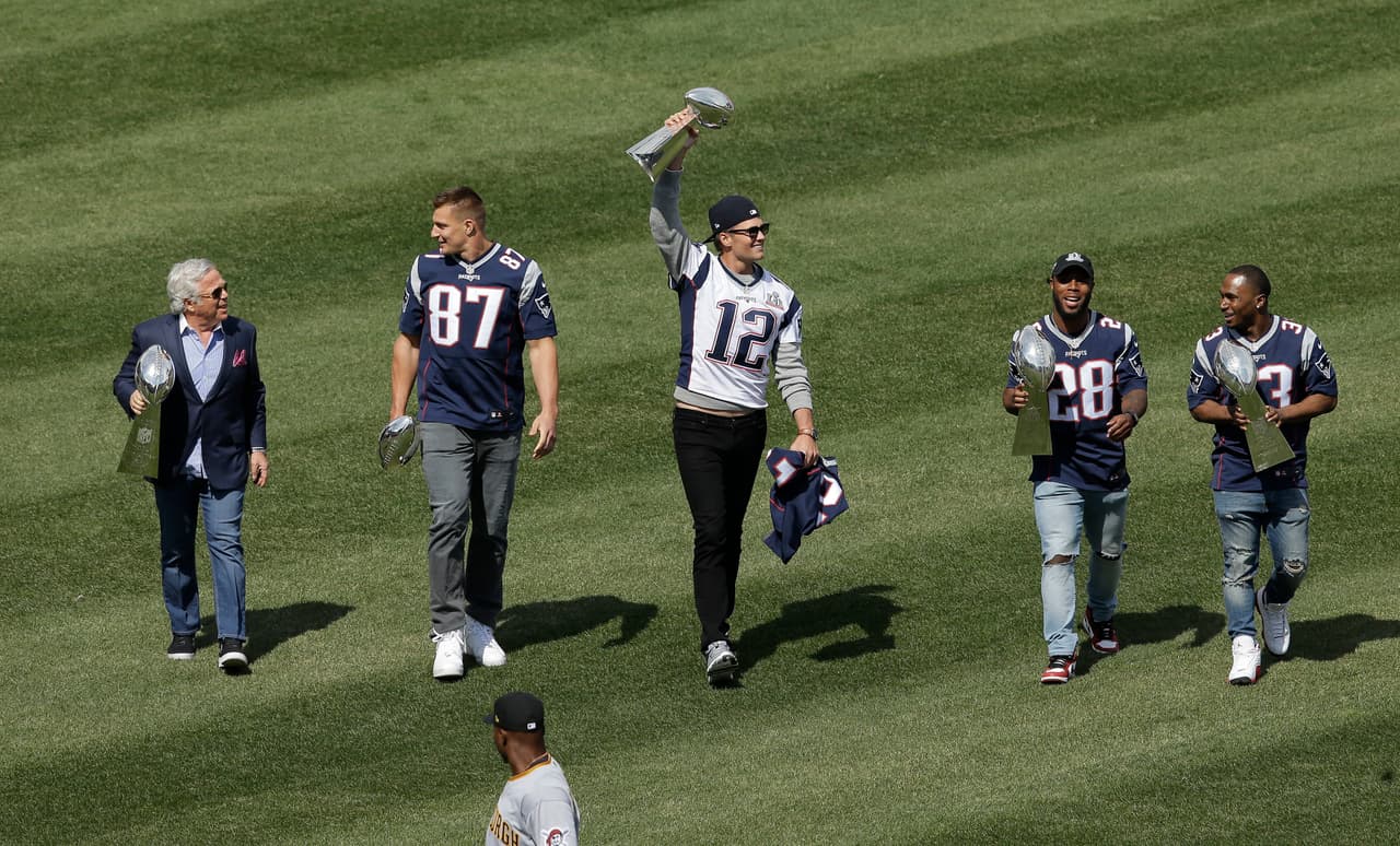 From left, New England Patriots owner Robert Kraft, and players Rob Gronkowski, Tom Brady, James White and Dion Lewis carry Super Bowl trophies off the field before a baseball game between the Boston Red Sox and the Pittsburgh Pirates on opening day at Fenway Park, Monday, April 3, 2017, in Boston. (AP Photo/Steven Senne)
