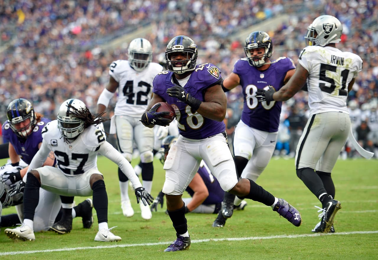 Baltimore Ravens running back Terrance West, center, scores a touchdown in the second half of an NFL football game against the Oakland Raiders, Sunday, Oct. 2, 2016, in Baltimore. (AP Photo/Nick Wass)