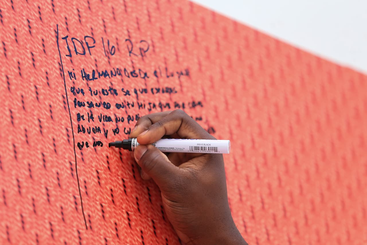 Momento en que Marcel Ozuna, jugador de los Marlins, firma el muro conmemorativo.