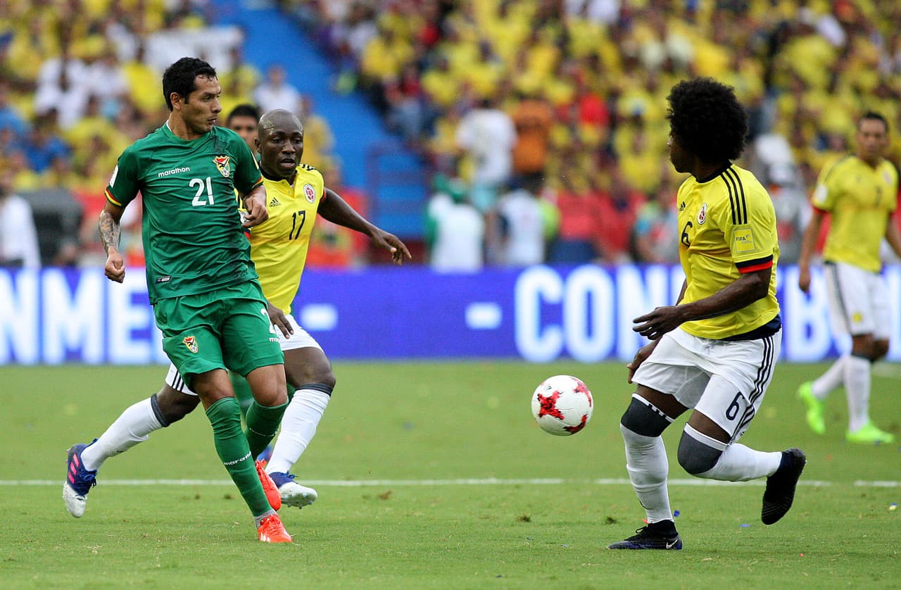Omar Morales (Bolivia) ante la marca de Pablo Armero y la mirada de Carlos Sánchez en el medio campo.