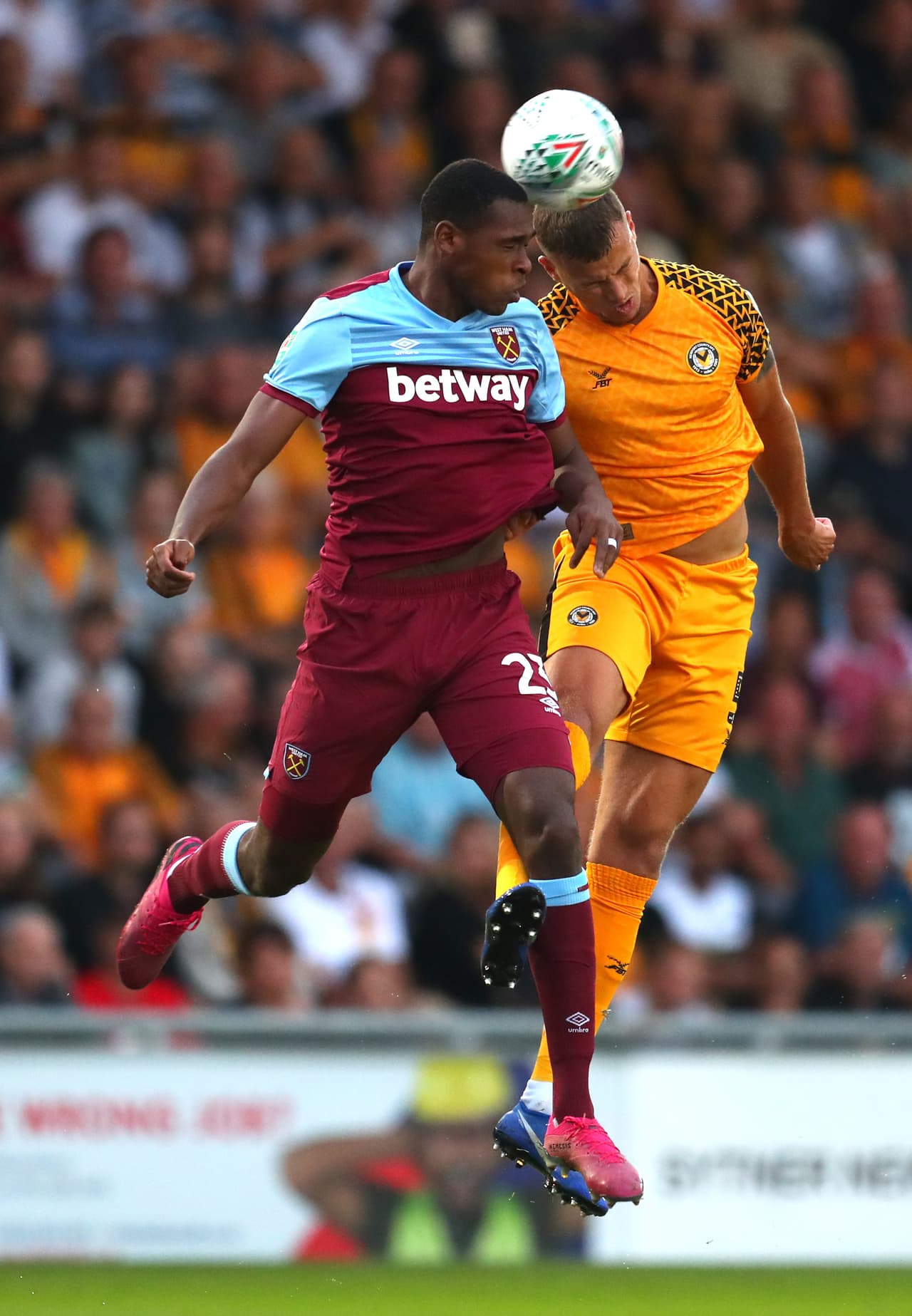 Issa Diop del West Ham salta para ganar el balón junto con Kyle Howkins del Newport County.