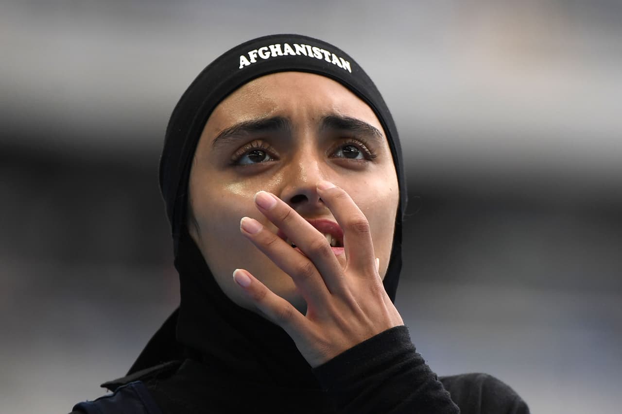 La atleta Kamia Yousufi (Afganistán) mira en la pantalla los resultados de la prueba preliminar de los 100 metros planos.