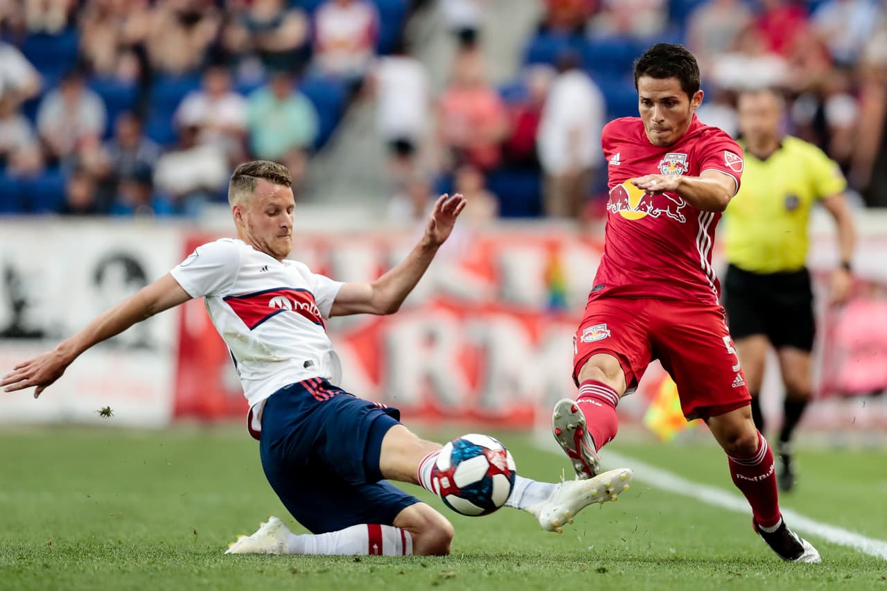 El alemán Bastian Schweinsteiger (izquierda) intentó frenar a Connor Lade (derecha) de los Red Bulls durante el juego.