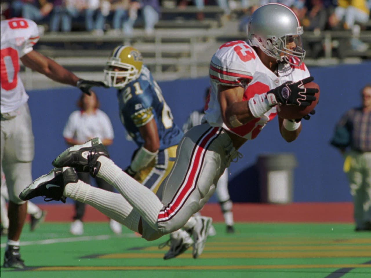 Ohio States' Terry Glenn crosses the goal line in mid-air to catch a touchdown pass from quarterback Bobby Hoying during first quarter action against the University of Pittsburgh, in Pittsburgh Saturday, Sept. 23, 1995. Glenn will decide whether to join such college stars as Nebraska's Lawrence Phillips, Michigan's Tim Biakabutuka and Texas A&M's Leeland McElroy and leave school early for the NFL draft. (AP Photo/Gary Tramontina)