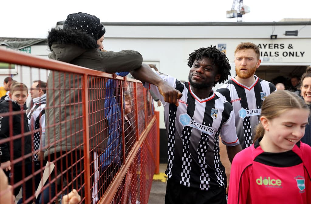 Saludo entre un jugador y un aficionado previo a la Liga Nacional Vanarama de Inglaterra.