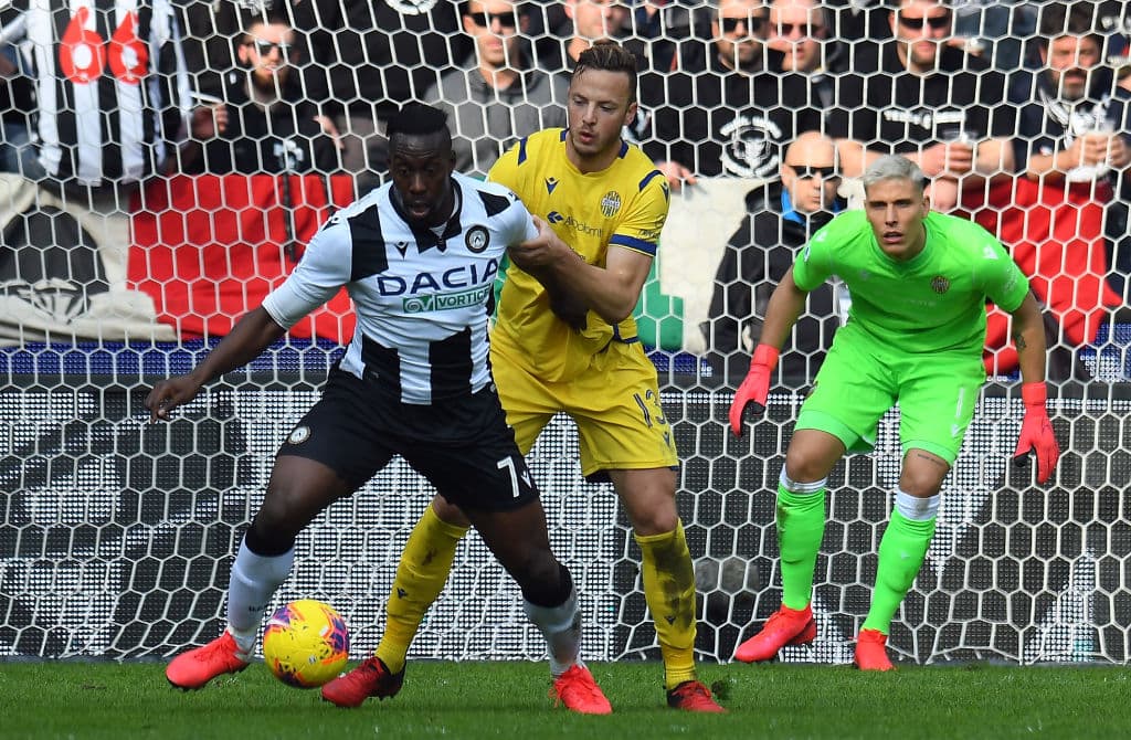 Stefano Okaka del Udinese intenta girar pero Amir Rrahmani del Hellas Verona le impide darse la vuelta.