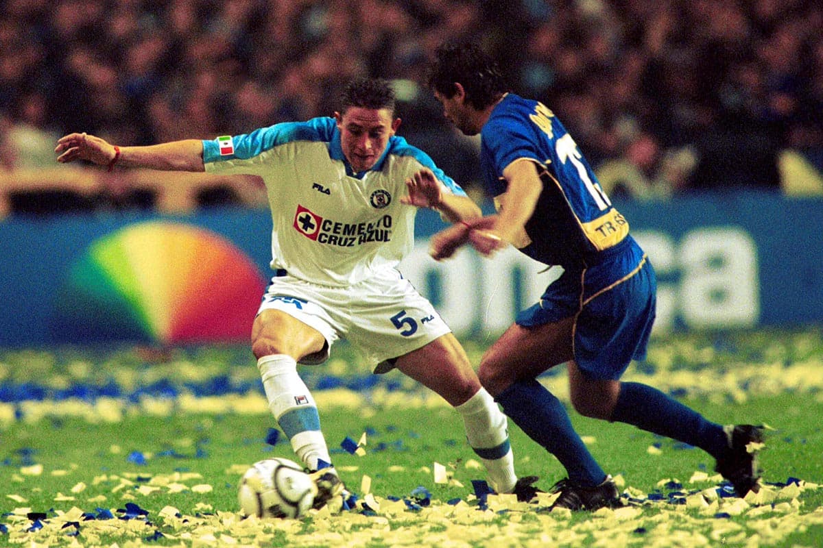 Víctor Gutiérrez (centro) en la marca al mediocampista de Boca Juniors Cristian Travelso (derecha) durante el partido de vuelta.